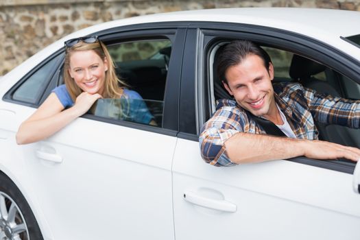 Couple smiling at the camera in their car