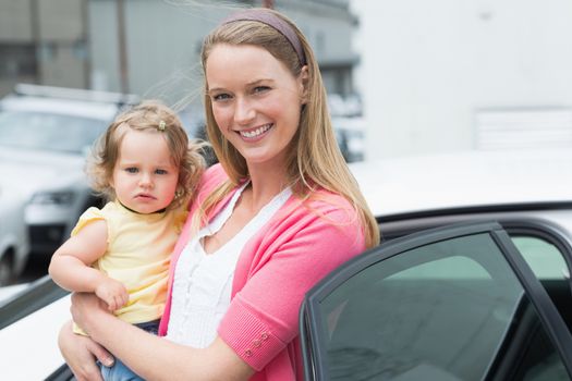 Pretty blonde with her daughter outside her car 