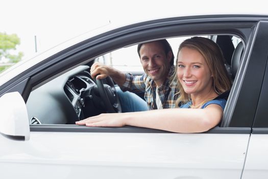 Couple smiling at the camera in their car