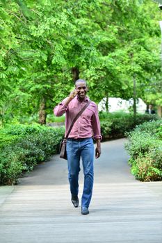 Handsome man talking on his cellphone while walking