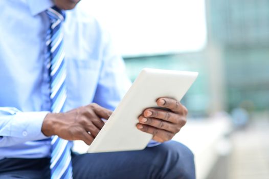 Cropped image of male hand operating digital tablet