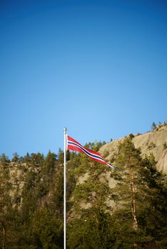 Norwegian pennant on a pole with mountains background