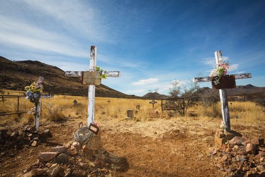 Trio of wooden crucifix burial sites with blank signs