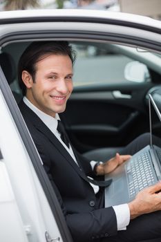 Businessman working in the drivers seat in his car