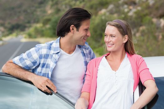 Couple smiling each other outside their car
