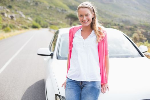 Pretty blonde leaning on the bonnet of her car 