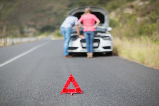 Young couple after a car breakdown at the side of the road