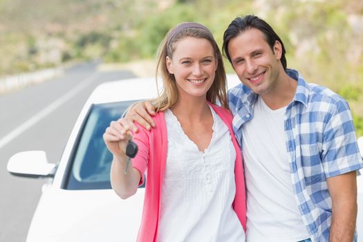 Couple showing key outside their car 