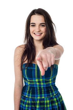 Pretty teen wearing modern attire and pointing towards the camera.