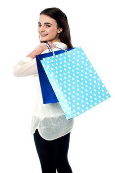 Young girl with shopping bags over her shoulders