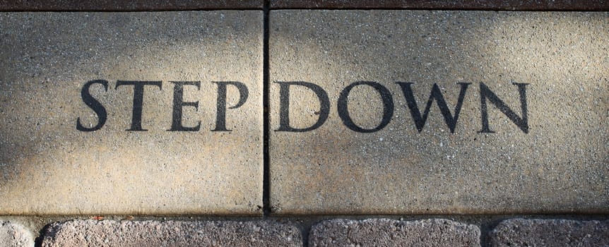 Stone step Down sign on the ground.