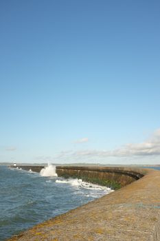 A view of waves breaking along the wall of the Holyhead breakwater, Anglesey, Wales, UK.