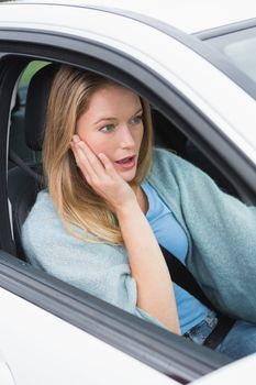 Surprised young woman in her car 