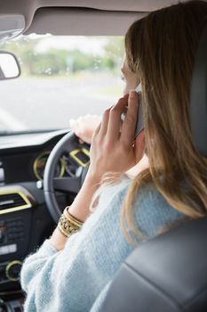 Young woman on the phone in her car