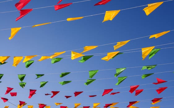 Bunting, colorful party flags, on a blue sky.