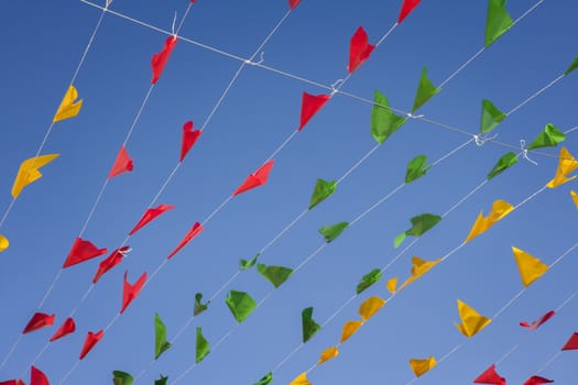 Bunting, colorful party flags, on a blue sky.