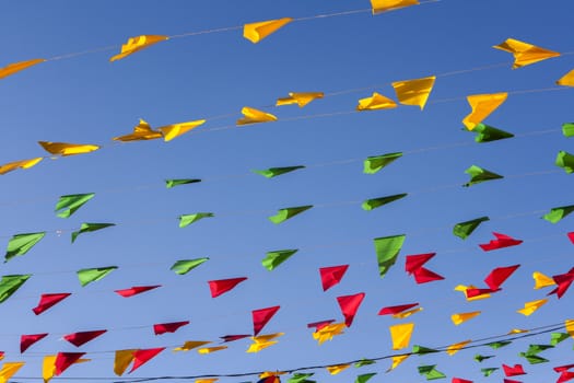 Bunting, colorful party flags, on a blue sky.