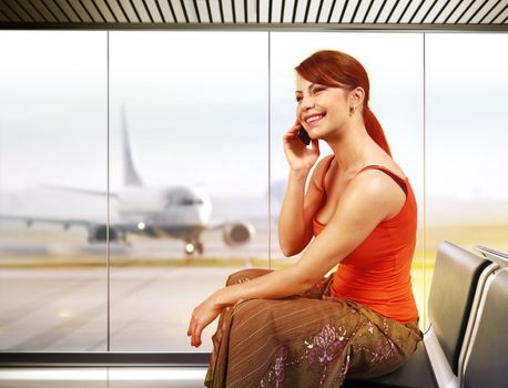 beautiful traveler with mobile phone in airport