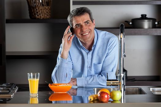 Man talking phone on breackfast in the kitchen