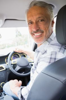Man smiling while driving in his car