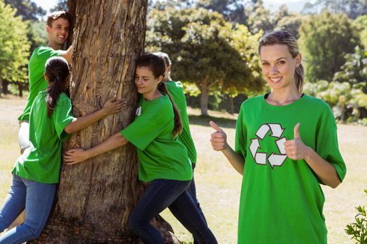 Environmental activists hugging a tree in the park on a sunny day