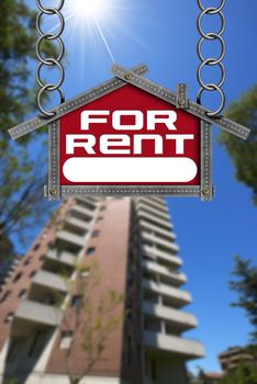 Grey metallic meter ruler in the shape of house with text for rent. For rent real estate sign with tall and blurred building in the background