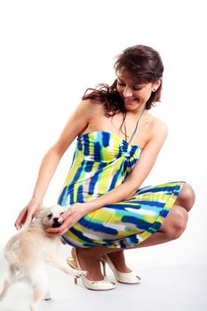 beautiful women in short dress on white background playing with dog