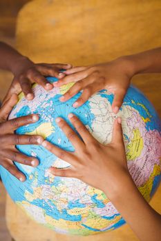 Close up of hands on globe in classroom