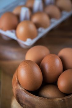 Fresh eggs at wooden plate closeup