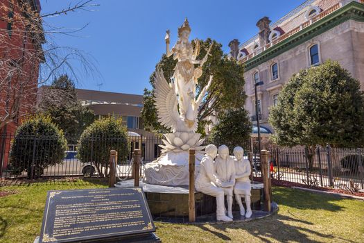 Hindu Goddess Dewi Saraswati Goddess of Knowledge and Wisdom Indonesian Embassy Embassy Row Massachusetts Avenue Washington DC Goddess is the Representative of Bali.  Goddess erected in 2014.  One of the students studying at the Goddess's feet is President Barak Obama when he was a little boy in Indonesia.  Statue built by five Balinese sculptors headed by Nyoman Sudarwa