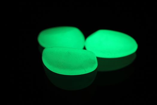 Green fluorescent stones on a mirror.