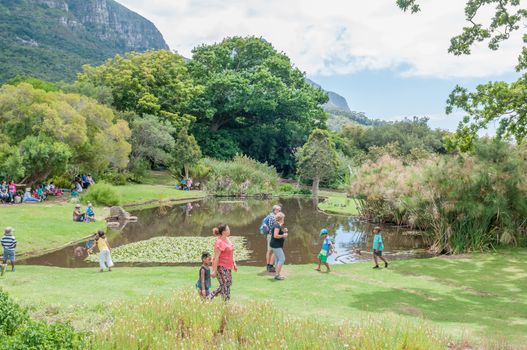 CAPE TOWN, SOUTH AFRICA - DECEMBER 9, 2014: Unidentified people in the Kirstenbosch National Botanical Gardens with part of Table Mountain visible