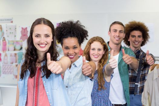 Portrait of confident and attractive fashion designers gesturing thumbs up