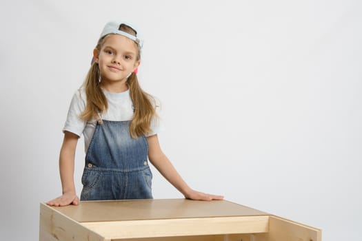 Six year old girl playing and collecting wooden cabinet
