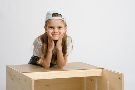 Six year old girl playing and collecting wooden cabinet