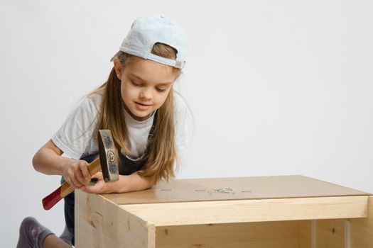Six year old girl playing and collecting wooden cabinet