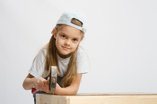 Six year old girl playing and collecting wooden cabinet