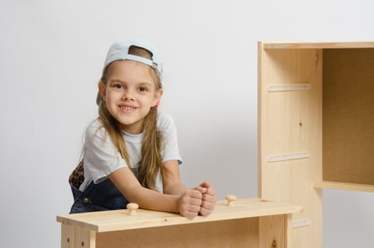 Six year old girl playing and collecting wooden cabinet