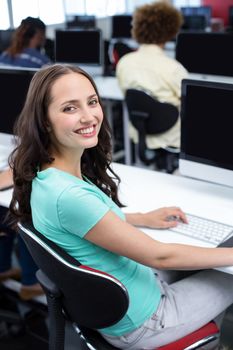 Female student smiling at camera in computer class