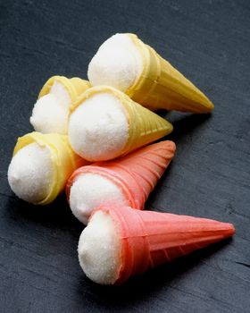 Heap of Tasty Ice Cream Cones closeup on Black Stone background