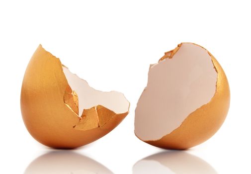 Gold egg shell hatched open over a white background