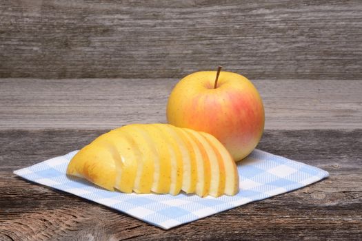 sliced apple on towel over wooden background