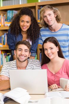 Group of college students using laptop in the library