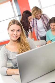 Portrait of female student using laptop in the classroom