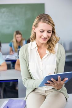 Portrait of female teacher using digital tablet in her class