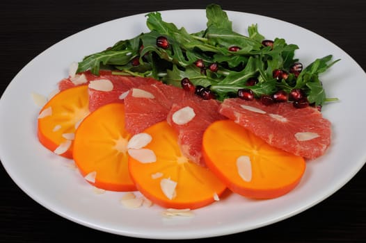 Salad of grapefruit, persimmon, arugula, almonds and pomegranate