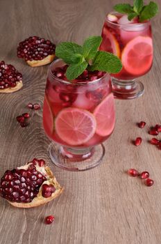 Pomegranate cocktail with slices of lime, mint and ice