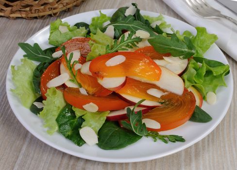 salad of spinach, arugula, lettuce, persimmon, apple and almonds