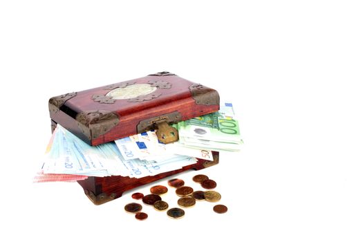Old wooden chest with euro banknotes and coins