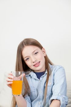 Pretty girl holding a glass with orange juice